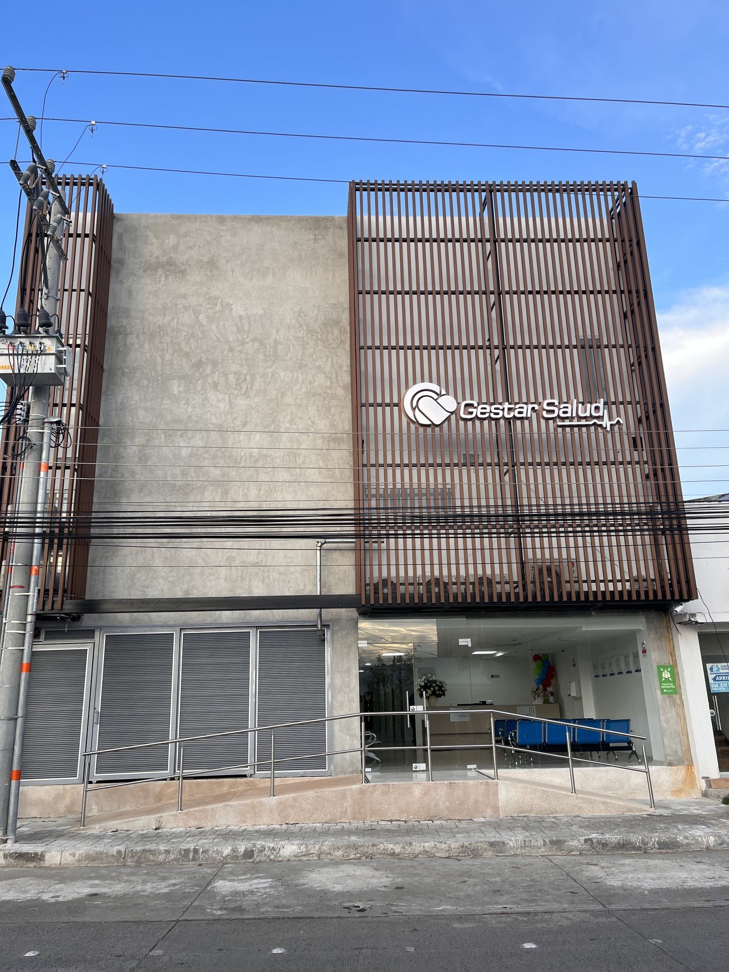 Fachada de la clínica con celosía de madera