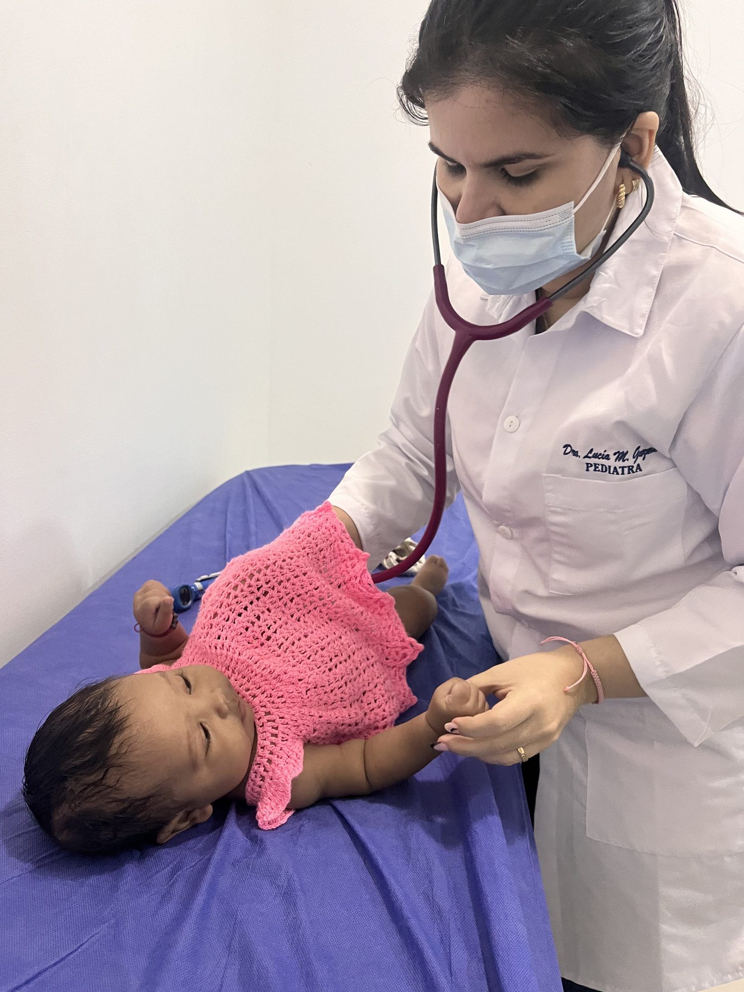 Pediatra auscultando a una bebé en consulta