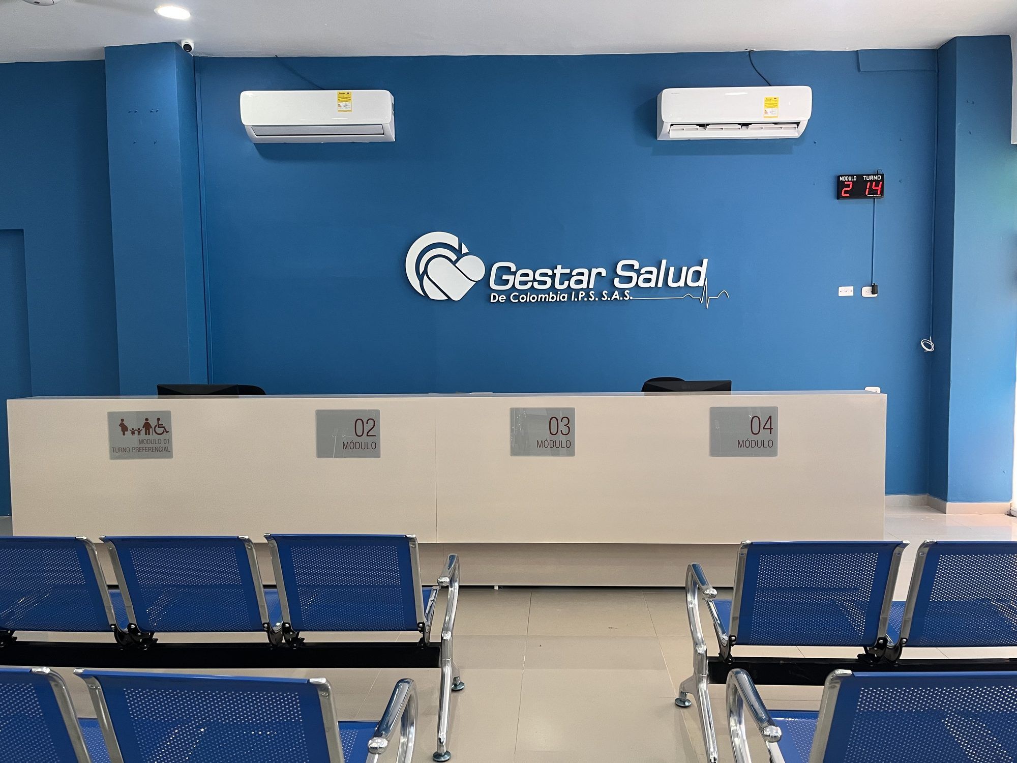 Sala de espera de una sede de Gestar Salud IPS, con el logo en la pared azul